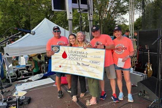 a group of people are holding a large check for the leukemia and lymphoma society .