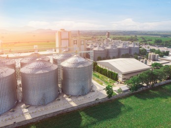 an aerial view of a factory with silos and buildings