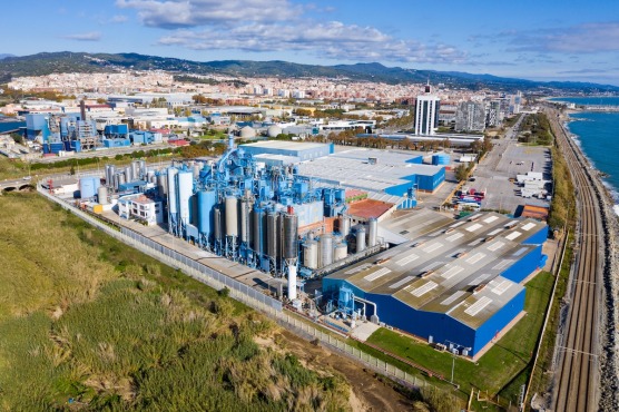 an aerial view of a factory with a city in the background